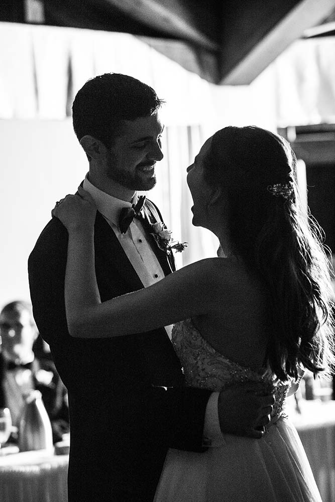 Newlyweds laugh during their first dance black and white portrait. wedding reception at White Pines Golf Club in Park Ridge, Illinois
