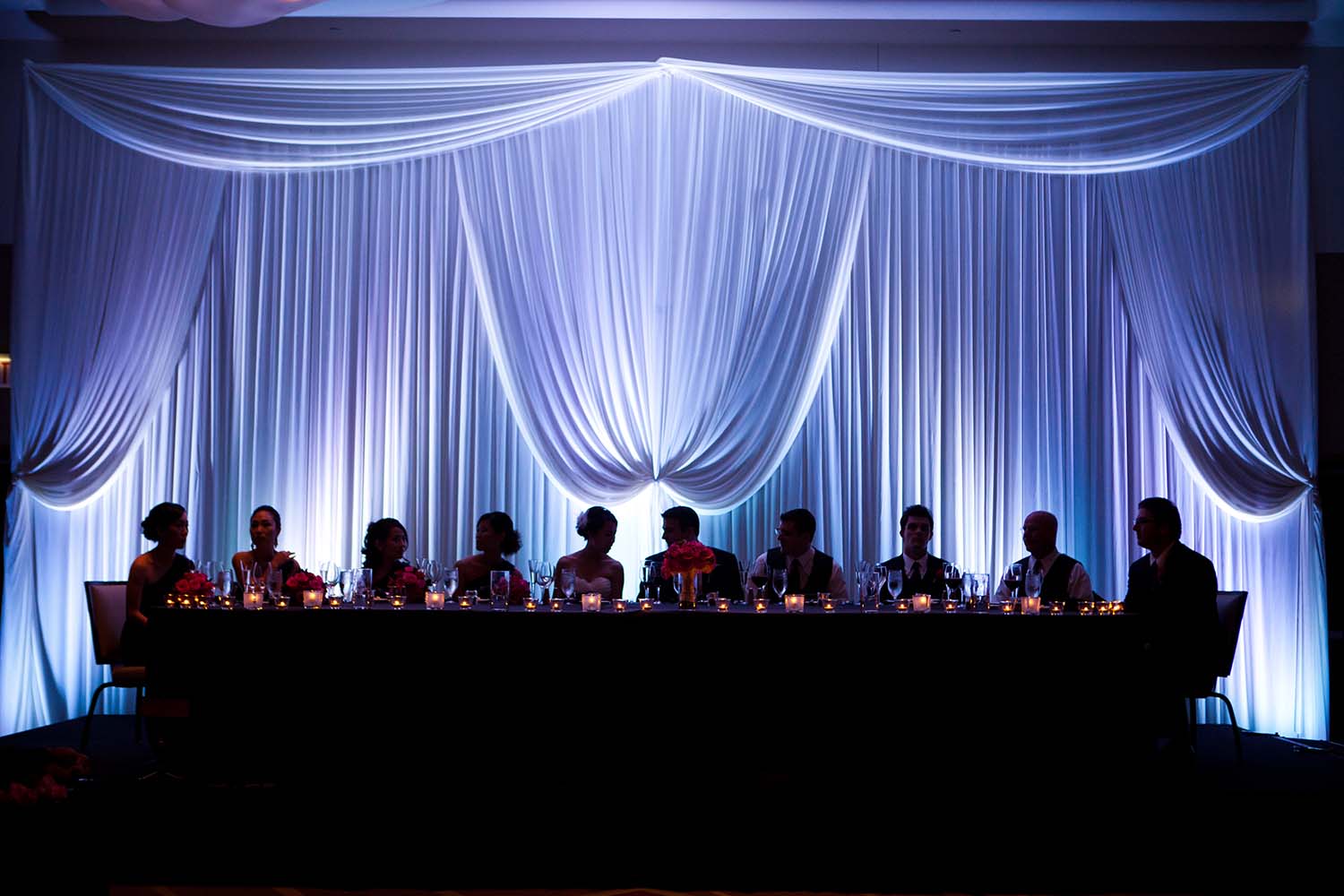 Silhouetted bridal party at reception table. Loews Hotel wedding reception. Minneapolis Wedding Photographer