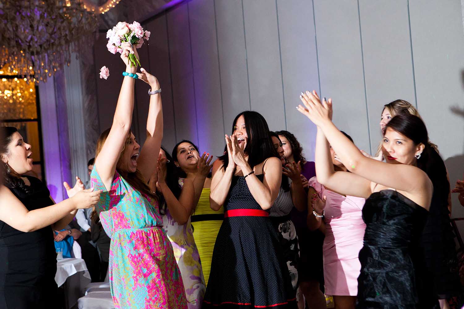 Bouquet toss wedding reception candid