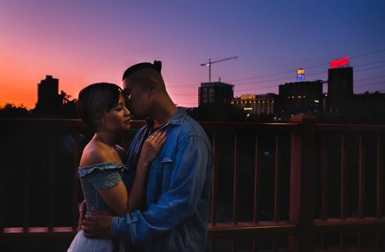 Asian couple romantic pose portrait at sunset on Stone Arch Bridge Minneapolis Engagement Photographers.